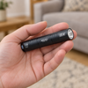 The black UV torch held in one hand, showing its palm size
