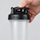 Thumb pressing the flip cap of a BlenderBottle Classic V2 down onto its screw-on lid to snap it shut
