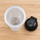 View into the wide mouth of a BlenderBottle Classic V2 cup, the stainless steel BlenderBall at the bottom, the black lid beside it
