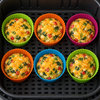 Six egg muffins baked in orange, pink, green and blue Webake silicone cases, standing in one layer in an air fryer basket
