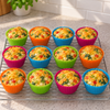 Twelve egg muffins in green, orange, blue and pink silicone cases cooling on a wire rack