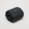 The jacket rolled loosely on a neutral surface, no bag or measure beside it.