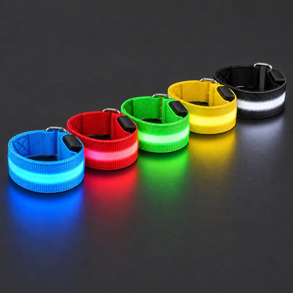 Five LED armbands lit on a dark surface: blue, red, green, yellow, and a black strap with a white light