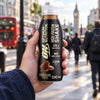A hand holding an Optimum Nutrition High Protein Shake 330ml bottle on the go