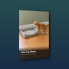 The Tray Check guide cover, a ginger tabby standing beside a large open litter tray