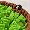 Close-up of the green felt strips, a piece of kibble tucked between them, and the gathered brown rim with its black cord toggle.