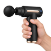 The massage gun held in one hand, showing its size