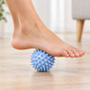 Spiky massage ball rolled under a bare foot