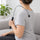Hook massage cane looped over the shoulder, knob on the upper back