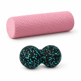 Pink foam roller and blue peanut massage ball on white