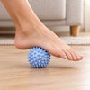 Spiky massage ball rolled under a bare foot