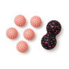 Five pink spiky massage balls and a pink peanut massage ball on white