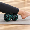 Calf resting on a peanut massage ball on the floor