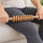 Rolling the wooden nine-roller stick along the thigh