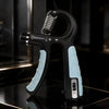 Black adjustable hand grip trainer with light blue non-slip handles, front dial and side counter, in a dark studio