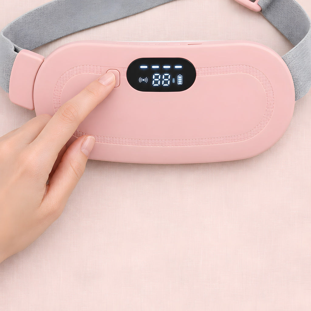 A finger pressing the button on the pink heated period belt, with the heat setting shown on the digital display