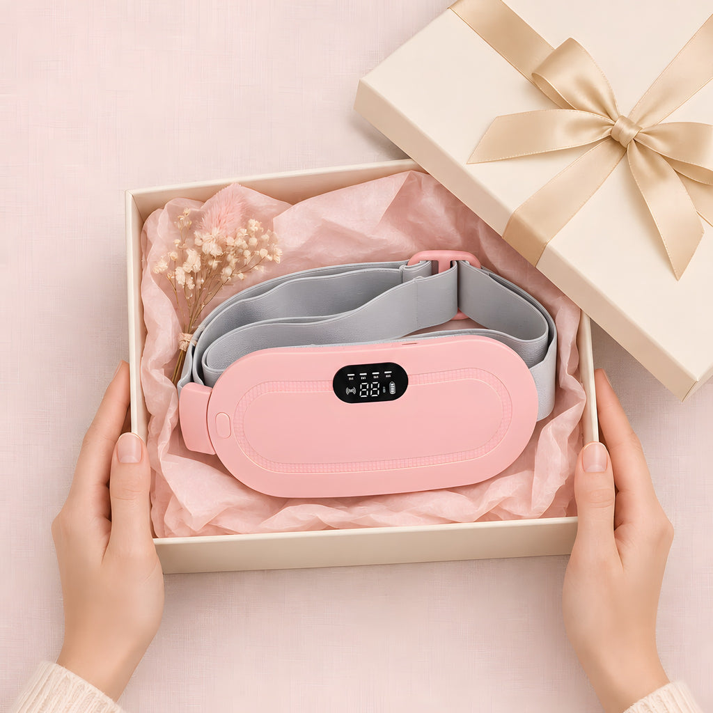 The pink heated period belt in an open gift box with pink tissue paper and a cream ribbon
